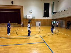 体育館の中で複数の生徒たちが、仮入部活動を楽しんでいる様子の写真