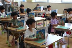 教室内で複数の小学生が、それぞれ自分の机に向かって教科書や本を広げ、熱心に学習に取り組んでいる様子の写真
