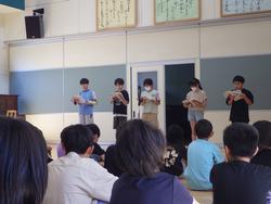 5人の生徒たちが前方に立ち、他の生徒たちに向かって本を読み上げている、わかばタイムの様子の写真