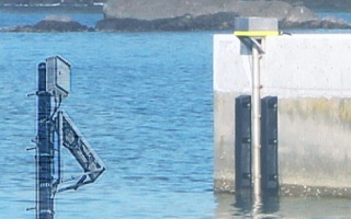 埠頭らしき場所にあるコンクリート製の壁と、水面に突き出した2つの装置が設置されている様子を捉えた写真(最新状況図のサイトへリンク)