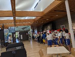 児童が魚竜化石の展示会場で化石の説明を受けている様子