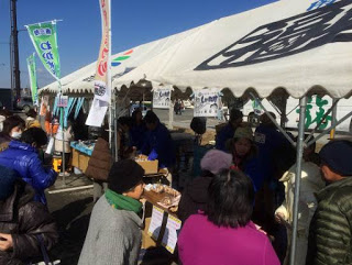 「わかめ」と書かれたのぼりが立ったテントに人が集まっている写真