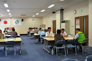 会議室で、数組の住民と相談員が向かい合って着席し、個別相談を行っている様子を写した写真