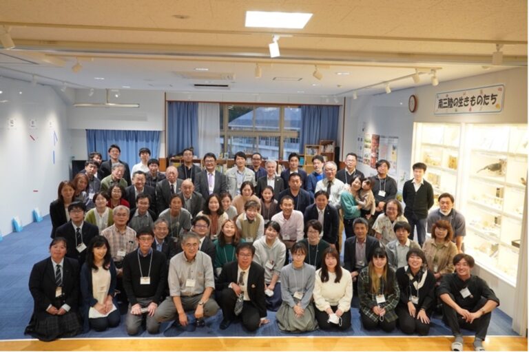 「南三陸いのちめぐるまち学会」にて室内で大勢の参加者が集合した写真