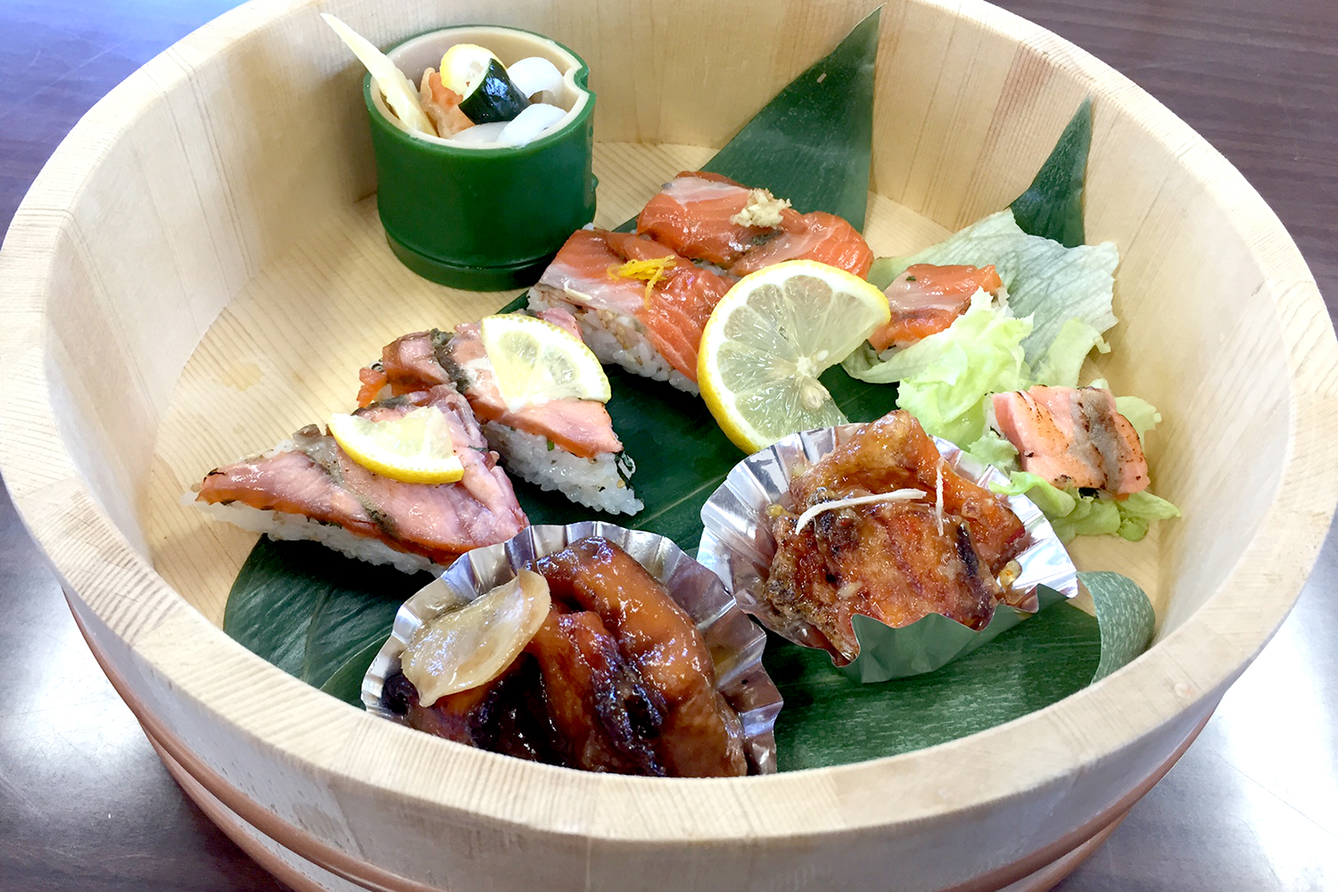 笹が敷かれた木桶に様々な銀鮭を使った料理が盛り付けられている写真