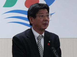 マイクの前に立つ佐藤町長の写真