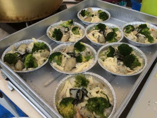 銀色のバットの上に、アルミの皿にブロッコリーとカキ、チーズなどが盛り付けられたものが8個並んでいる写真