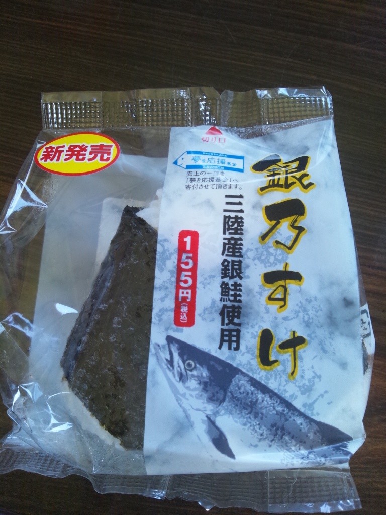 「新発売」のシールが貼られた、鮭の絵と「銀乃すけ 三陸産銀鮭使用」という商品名が記載されたパッケージに包まれた、海苔付きのおにぎりの写真