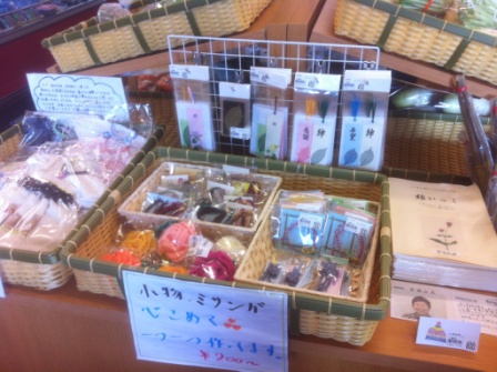 手作りのしおりやストラップ、小物などが入ったカゴが並んだ手芸品コーナーの写真