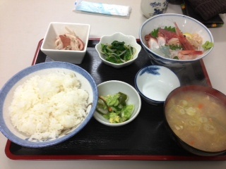 ごはん、みそ汁、お漬物、小鉢に入った野菜や海産物、お刺身などの料理がお盆に並べられている定食の写真