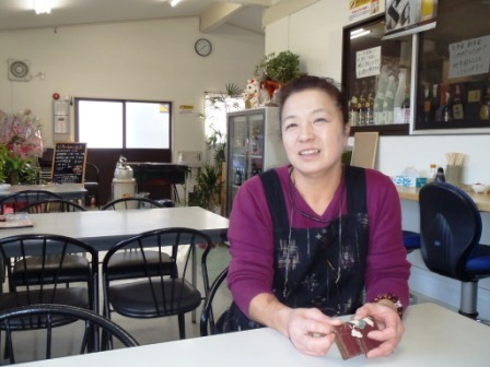 店内のテーブルに座っている成澤英子さんの写真