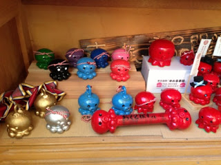 タコをモチーフにした赤や青、金色、銀色などの合格祈願「オクトパス君」の置物の商品がたくさん並んでいる写真