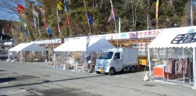 伊里前福幸商店街の店先に立てられた色とりどりのJリーグのフラッグと仮説テントの店舗の様子を写した写真