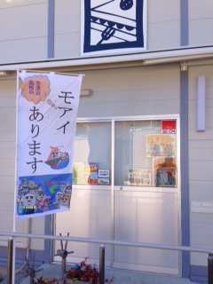 建物の入口に「モアイあります」と書かれたのぼり旗が店舗前に立てられている写真