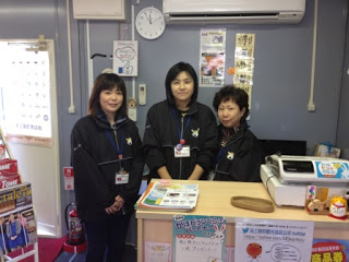 カウンターの中に立つ女性スタッフ3名がそろいのジャンパーを着て笑顔で写っている写真