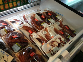 冷蔵庫の中にパック詰めされたタコがたくさん並んでいる写真