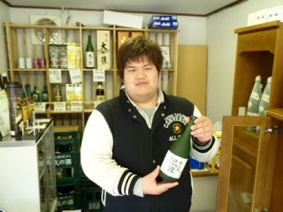 店主の佐藤さんが店内で歌津の酒瓶をもって写っている写真
