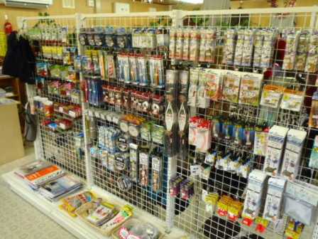 白い金属製のラックに釣り用の小物が種類別にかけられてる売り場の写真