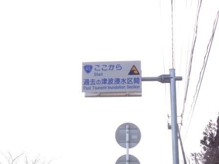 電柱に取り付けられた「ここから(Start)過去の津波浸水区間(Past Tsunami Inundation Section)」と書かれた案内標識の写真
