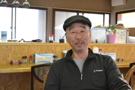 店の中で店主の澤田力さんが笑顔で写っている写真