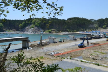 左側に一部分の橋桁が残り橋脚が点々と残り、多くの重機で工事をしている橋桁歌津大橋の解体工事中の写真