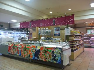 スーパー内の一角に「歌津小太郎」と書かれたのれんがかかり、海藻製品などが並べられた売り場全体を写した販売ブースの写真