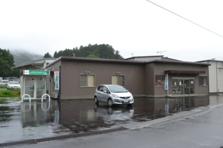 茶色の外壁の平屋建ての建物で、ATMコーナーが隣接しているJA南三陸 志津川営農センターの外観写真