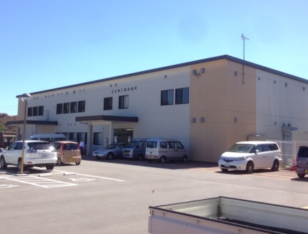 白を基調とし、一部ベージュの外壁、2階建ての建物で診療所の建物の前に広々とした駐車場となっている公立志津川病院仮設診療所の外観写真