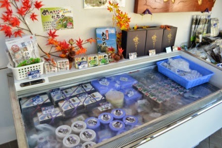 冷凍ケースの中に商品が整然と並べられており、上部には紅葉の装飾や常温商品がディスプレイされている写真