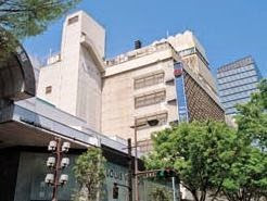 ベージュ色の外壁を持つ藤崎デパートの建物を、地上から見上げるような角度で撮影した写真