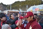 楽天イーグルスのユニフォームを着た牧田明久外野手と思われる人物が、勝利報告会で集まったファンと笑顔でハイタッチを交わしている、にぎやかな交流の様子を写した写真