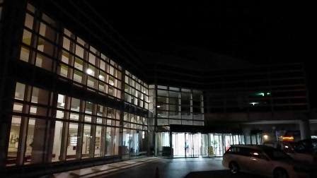 明かりが灯る大きな窓が特徴のモダンな建物の夜景で、その正面には自動ドアのエントランスがあるベイサイドアリーナの外観を写した写真