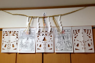 部屋の壁にしめ縄とともに、お供物をかたどった「きりこ」丁寧に飾られている神棚飾りの写真