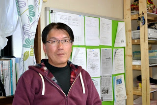 あずき色のジャンバーを着てメガネをかけた石川さんの写真