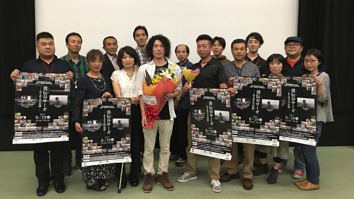 映画『願いと揺らぎ』の上映イベント後に、出演者や関係者が映画ポスターを手に持ち、監督が花束を抱えて中央に立っている集合写真