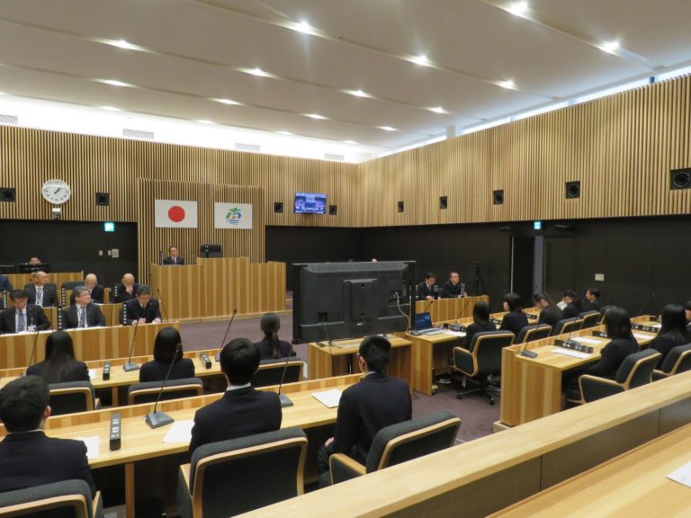 役場の議場で、町長や各課課長と生徒たちが議論に参加している様子の写真