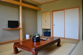 畳敷きの和室にテレビと座卓が置かれ、落ち着いた雰囲気の客室の内部が写っている写真