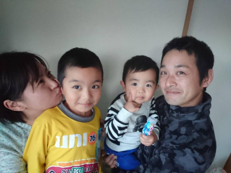 2人の男の子を中心に阿部さん夫妻が並び、清美さんは隣の男の子の耳にキスをするポーズをしている写真