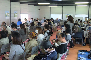 簡易的な会場に多くの住民が集まり、順番を待っている様子を写した写真