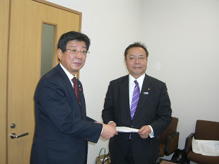 佐藤町長が谷公一復興副大臣に要望書を手渡ししている様子の写真