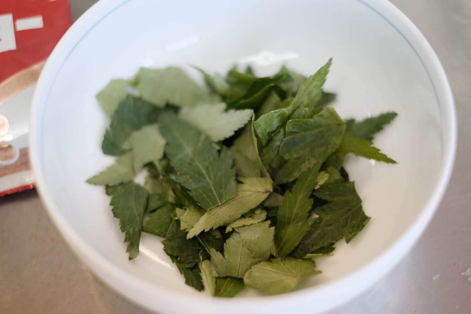 白いお皿にトウキ葉が小さく切られて入れられている写真