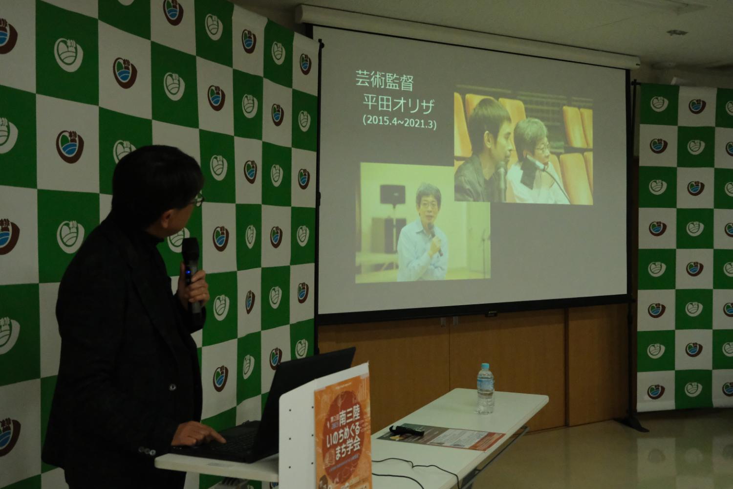 南三陸町の人口動態に関するデータを示しながら講演を行う中見宗治さんの写真