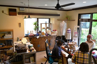 雑貨店の室内に数人の女性がテーブルを囲んで作業をしており、窓際や棚には手芸用品が並んでいる明るい店内の写真