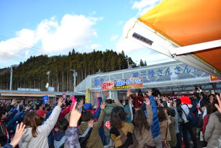 会場の観客の皆さんが掛け声に合わせて、右手を上に挙げて歓喜で盛り上がっている様子の写真