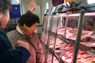 お造りコーナーのショーケースの前で年配の女性2人が商品を見ている写真