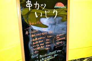 串カツいじりと書かれ、メニューがのった看板の写真