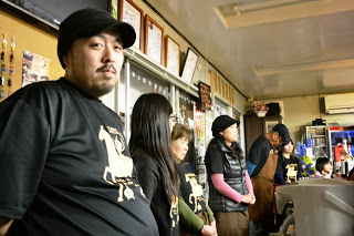 同じロゴ入りTシャツを着ているスタッフの皆さんが一列に並んで立っている様子の写真