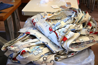 車や飛行機の柄が入った布製のバッグが積み重なって置かれている写真