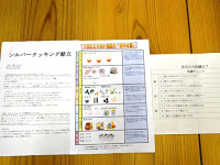 イラストや文字で栄養や健康について説明されている「シルバークッキング献立」の配布資料がテーブルの上に広げられている写真