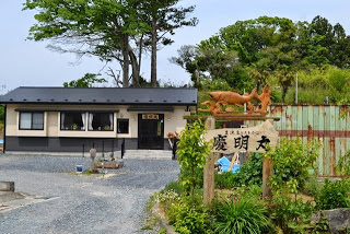 「慶明丸」の看板の奥に立つ店舗全体を写した写真